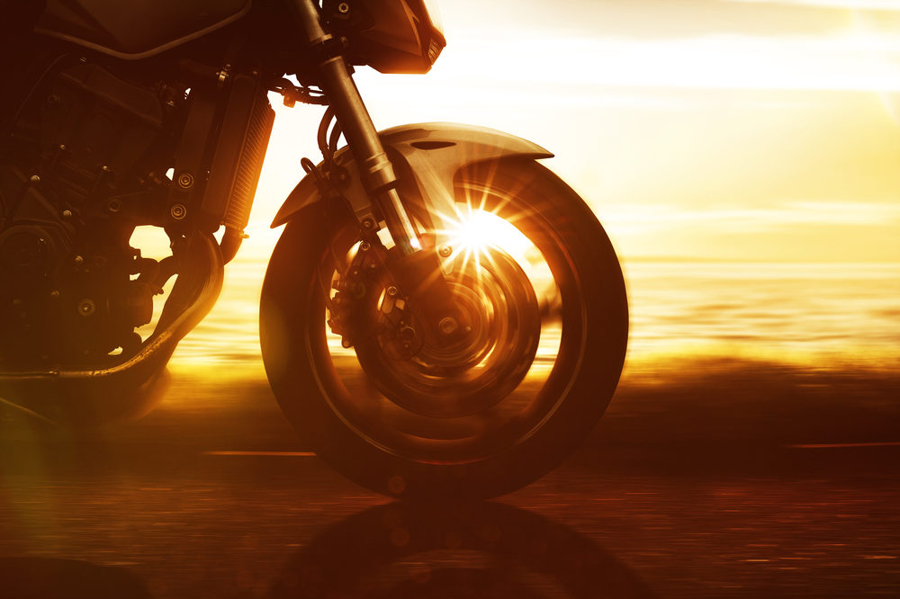 closeup of motorcycle front wheel with sunlight background