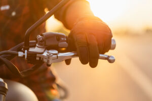 left hand of motorcyclist wearing riding glove on the clutch.