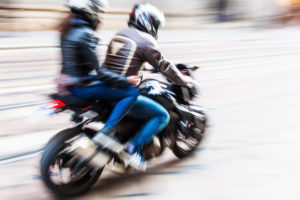 blurred image of a motorcyclist with a passenger 