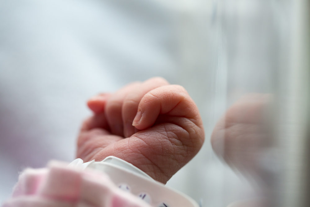 a newborn baby's hand closeup in an incubator