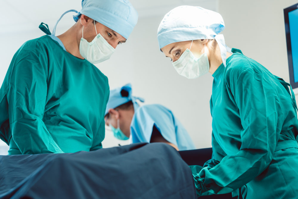 Doctors and surgeons operating on patient in hospital 