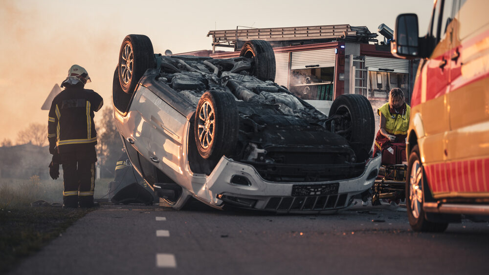 overturned suv Smoking Lying on its Roof in the Middle of the Road after Collision.