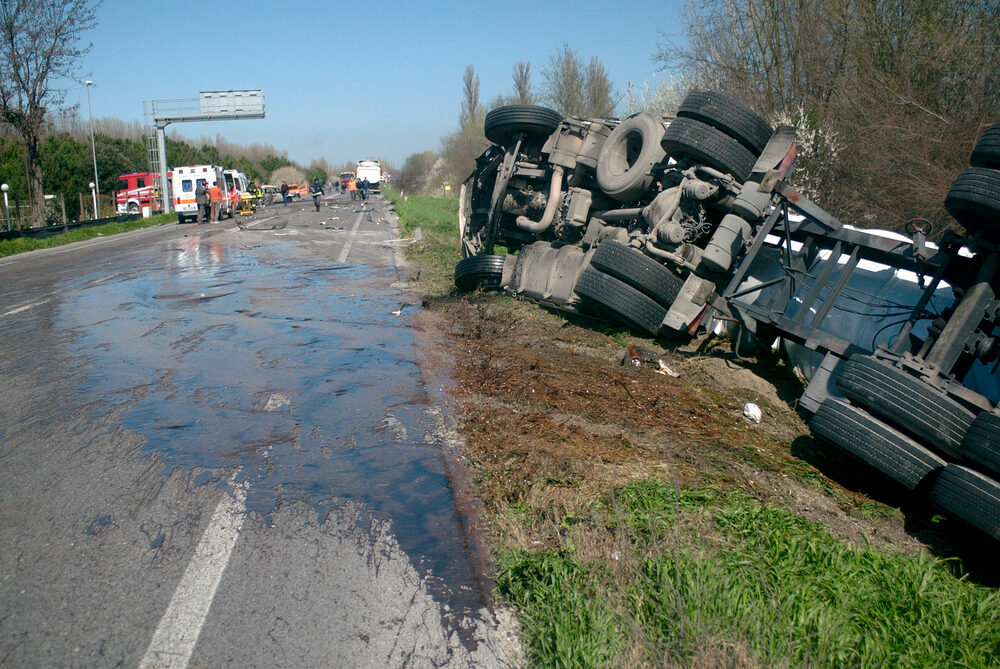 view of overturned truck accident with ambulance and emergency vehicles on  site