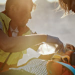 paramedics applying an oxygen mask to a female accident victim in a stretcher