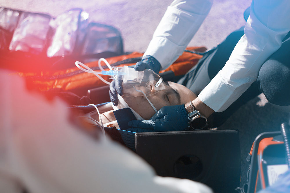 paramedic treating an injured man on a stretcher with a neck brace