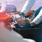paramedic treating an injured man on a stretcher with a neck brace