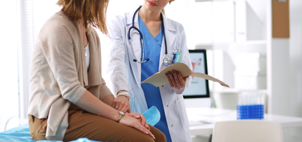 Female patient and doctor discussing something in a medical office