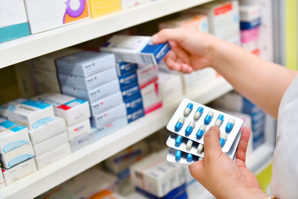 A pharmacist taking medications off a shelf