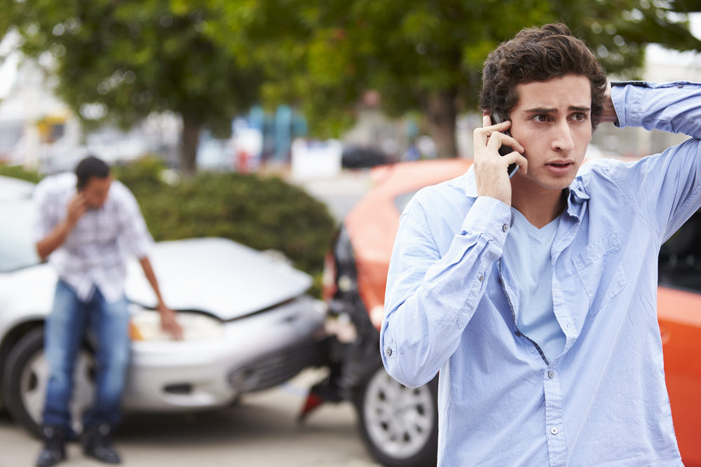 Teenage Driver Making Phone Call After Traffic Accident