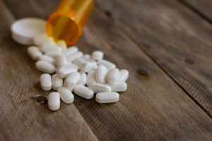 pharmaceutical opioid pills spilled out onto wooden table