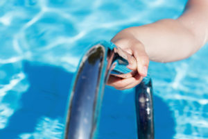 Female's hand holding a handrail in a swimming pool