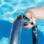 Female's hand holding a handrail in a swimming pool