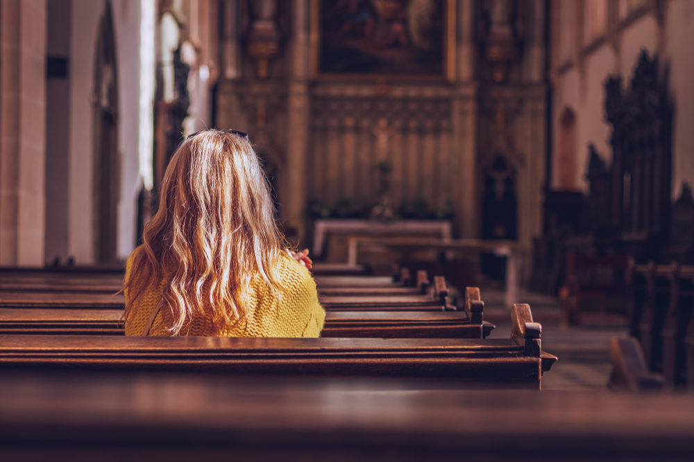 Travis Payne Named in SBC Guidepost Abuse Report Young woman praying and meditating in church.