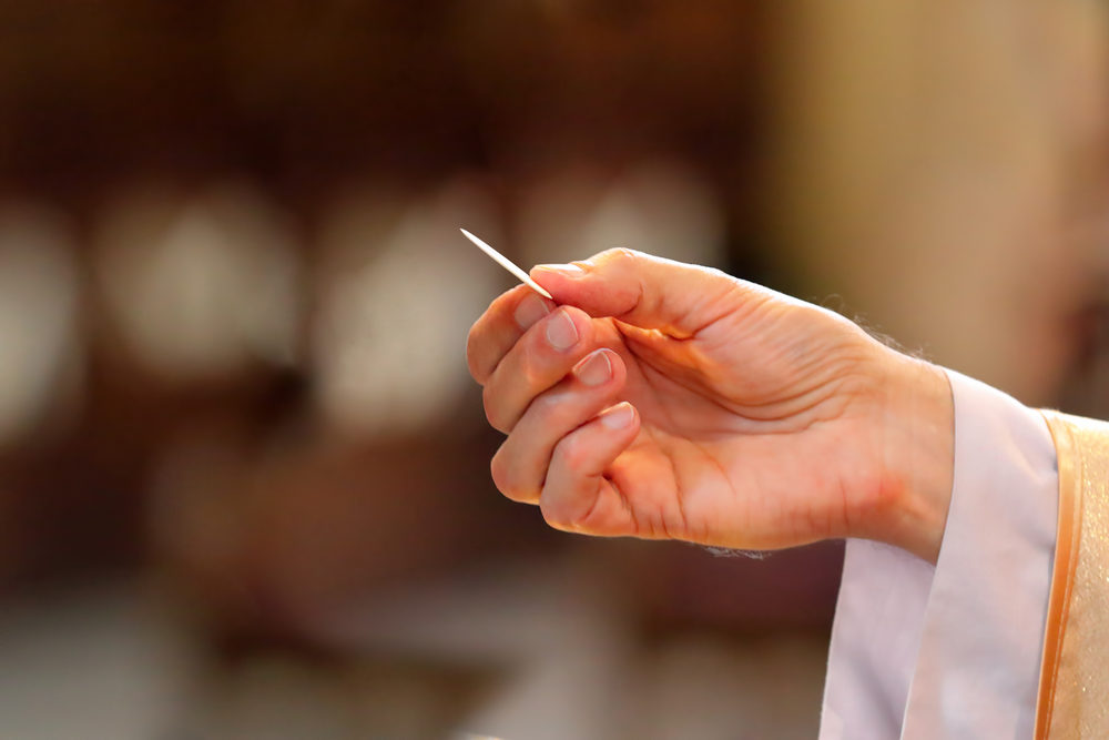Priest gives holy communion to faithful