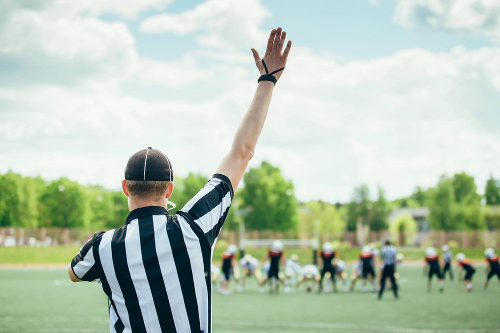 American Football played by young men with game official linesman referee