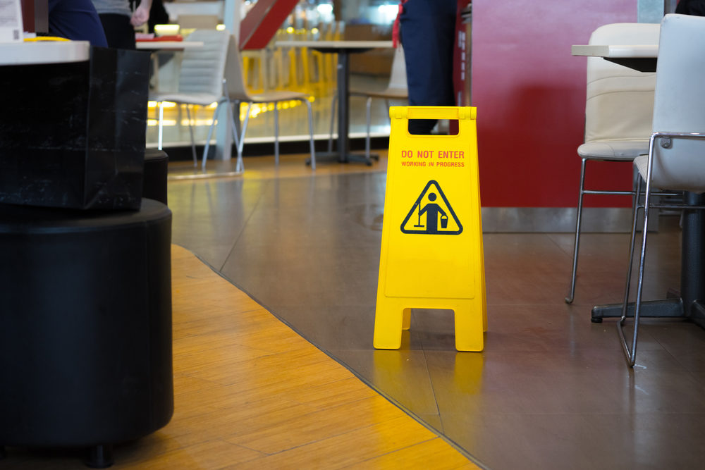 Yellow sign that alerts for wet floor in the restaurant