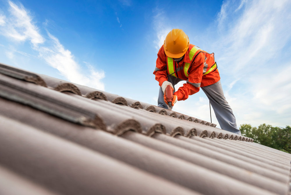 Builder in work clothes install new roofing