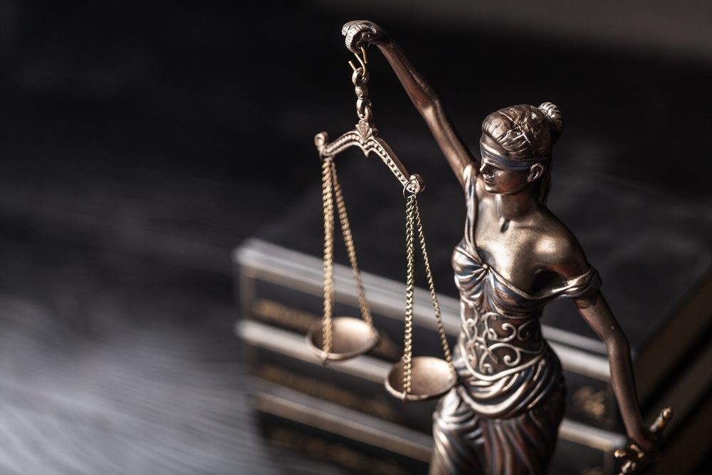 closeup on lady justice scales on a desk