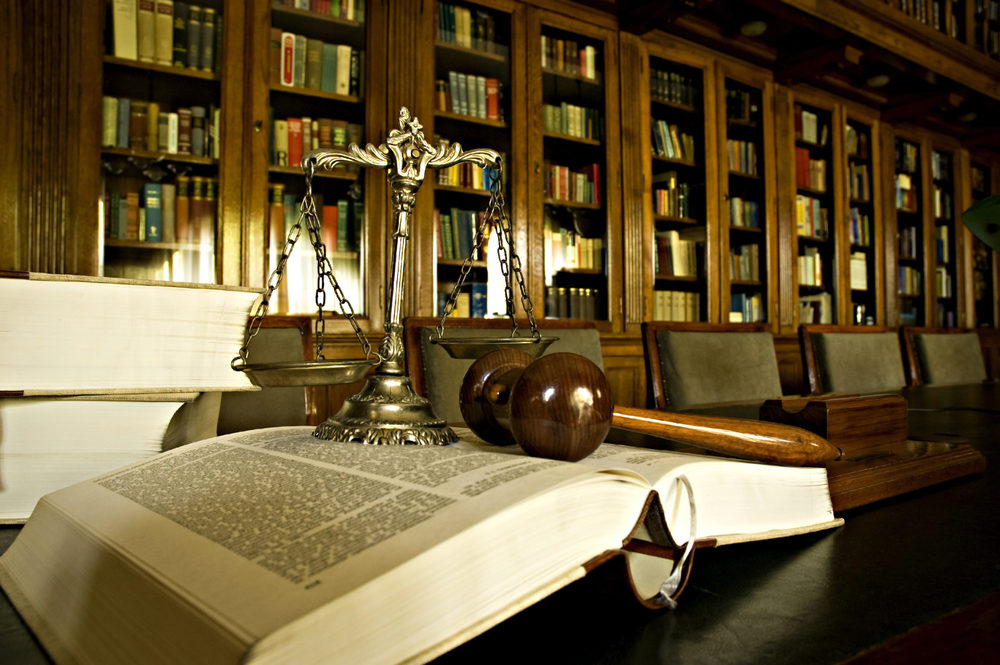 The Art of Settlement – A Lawyer’s Guide to Regulatory Compliance when Resolving Catastrophic Claims Scales of justice and gavel laying on law book in library