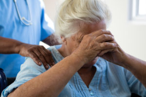 Midsection of nurse consoling senior woman at nursing home