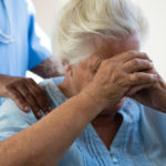 Midsection of nurse consoling senior woman at nursing home