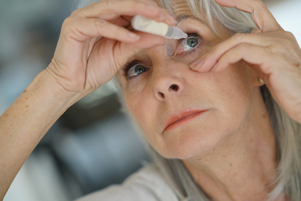 Senior woman putting eye drop