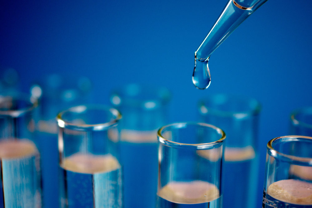 The EPA Soon to Require Manufacturers to Report More Info on PFAS Production A dropper adds clear liquid to a glass test tube