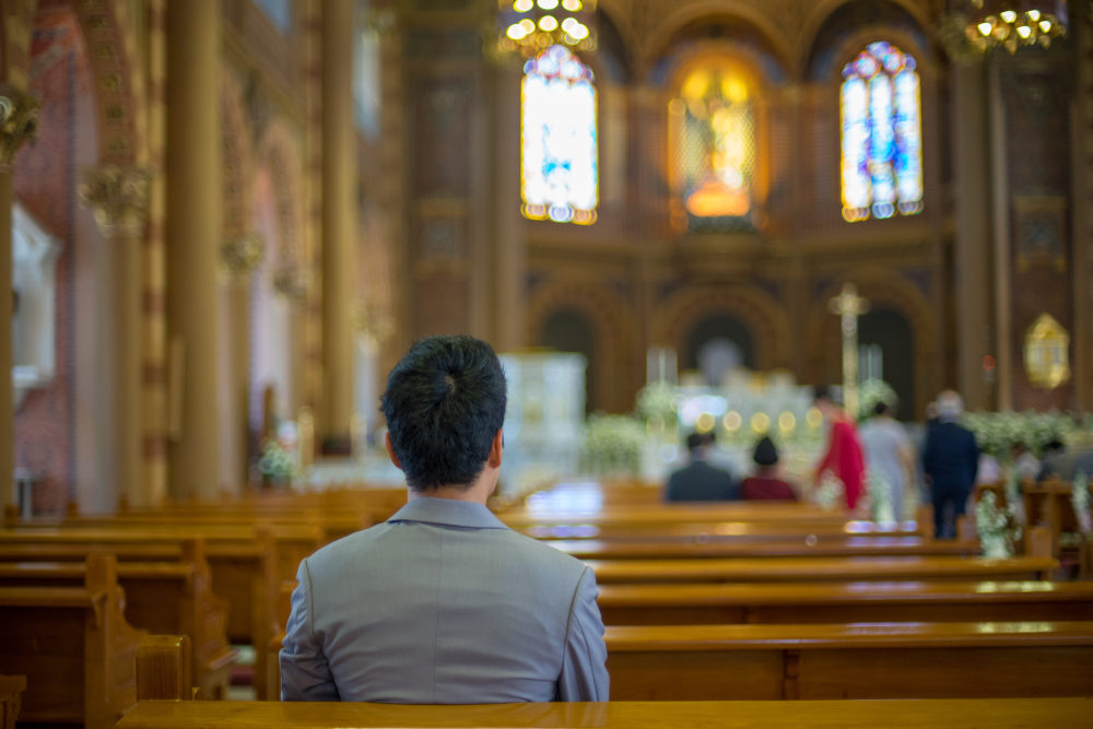A man sits in a pew during a church service
