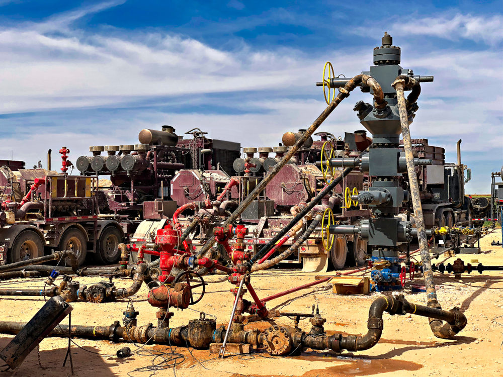 Lots of fracking machinery, including a well head connected to franking pumps