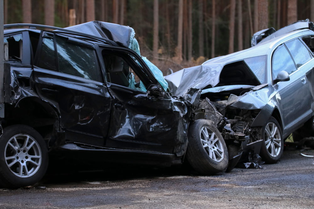 Two demolished SUVs on the road following a head-on collision