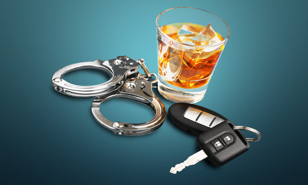 A glass of alcohol, a key fob, and a pair of handcuffs