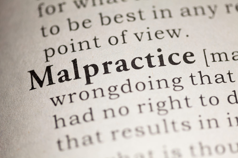Close-up of the word "Malpractice" in a dictionary