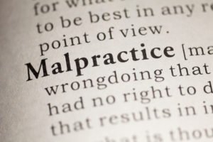 Close-up of the word "Malpractice" in a dictionary