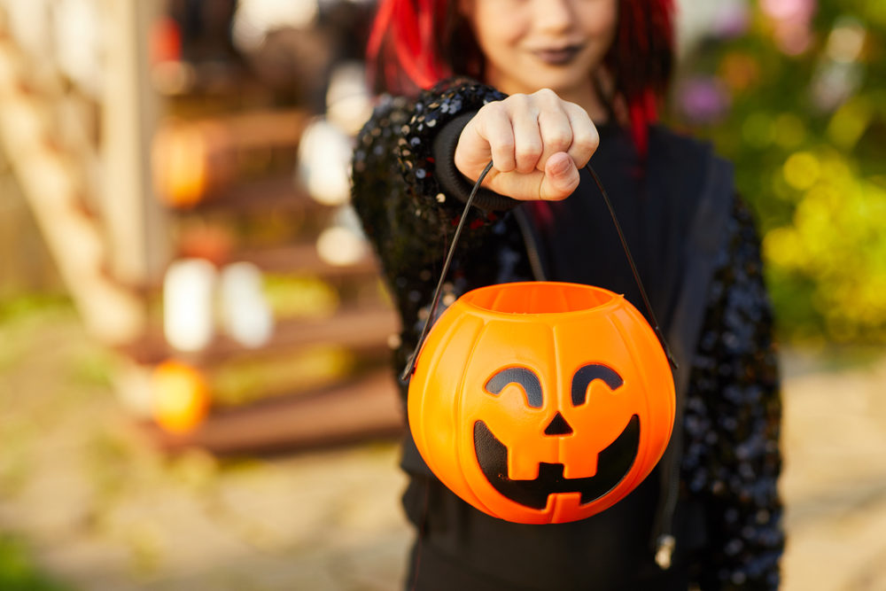 Halloween Safety Tips in Virginia A girl holding out a pumpkin basket for Trick-or-Treating