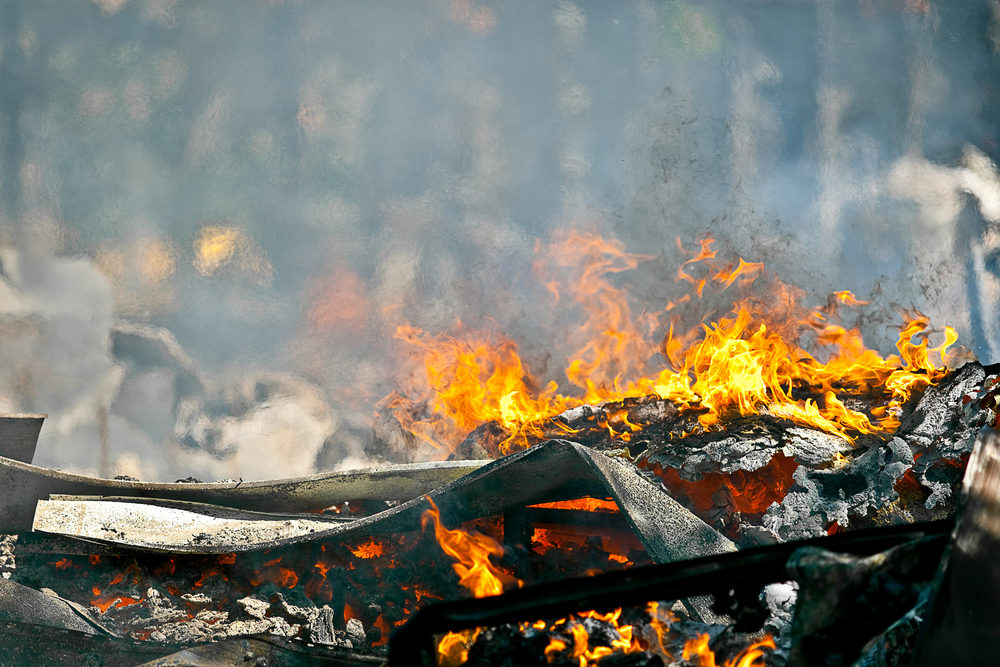 Building materials still burn after a devastating fire