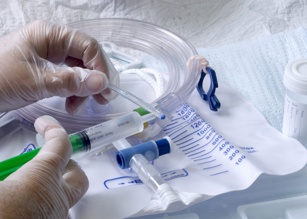 A nurce lubricating a urinary catheter