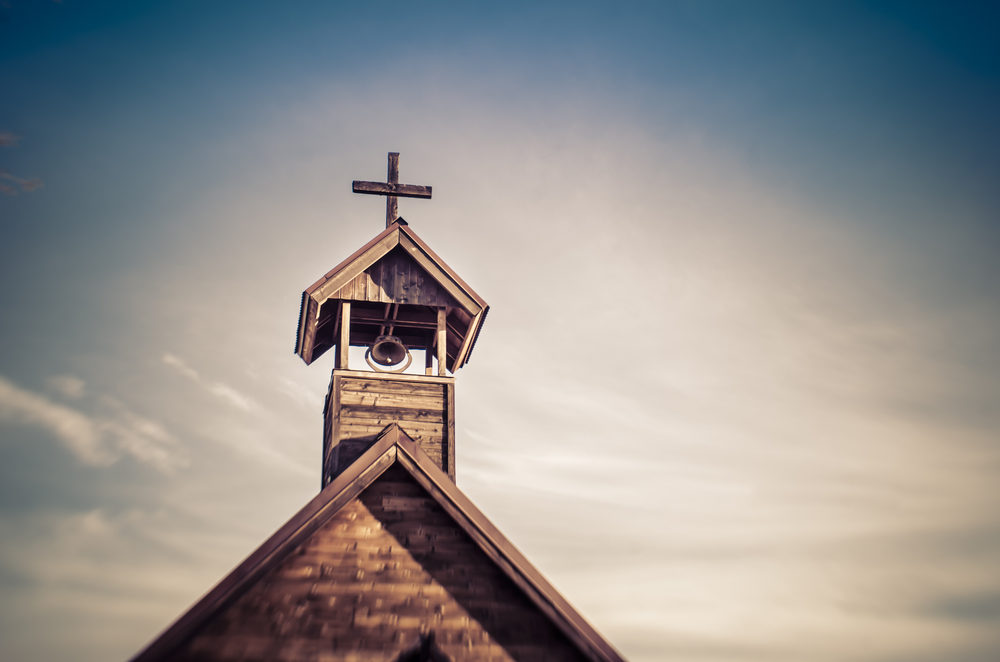The cross and steeple of a rural wooden church