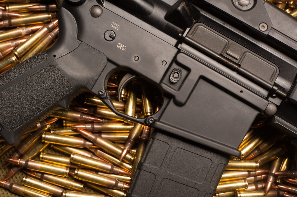 AR15 rifle resting on a pile of ammunition
