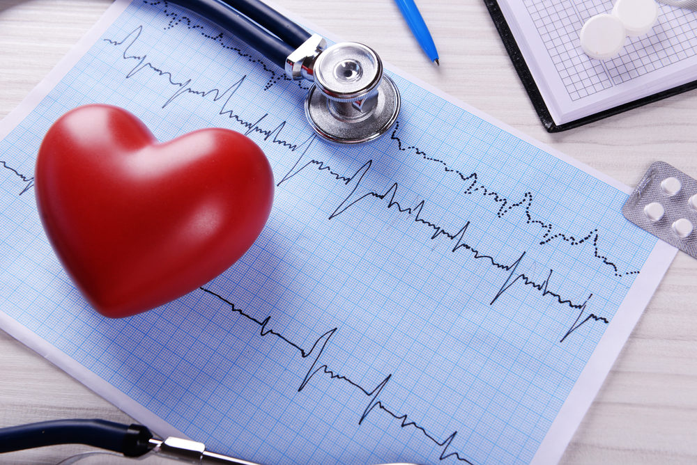 A 3d rendered heart laying on an EKG readout