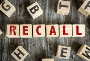 Wooden block spelling the word RECALL