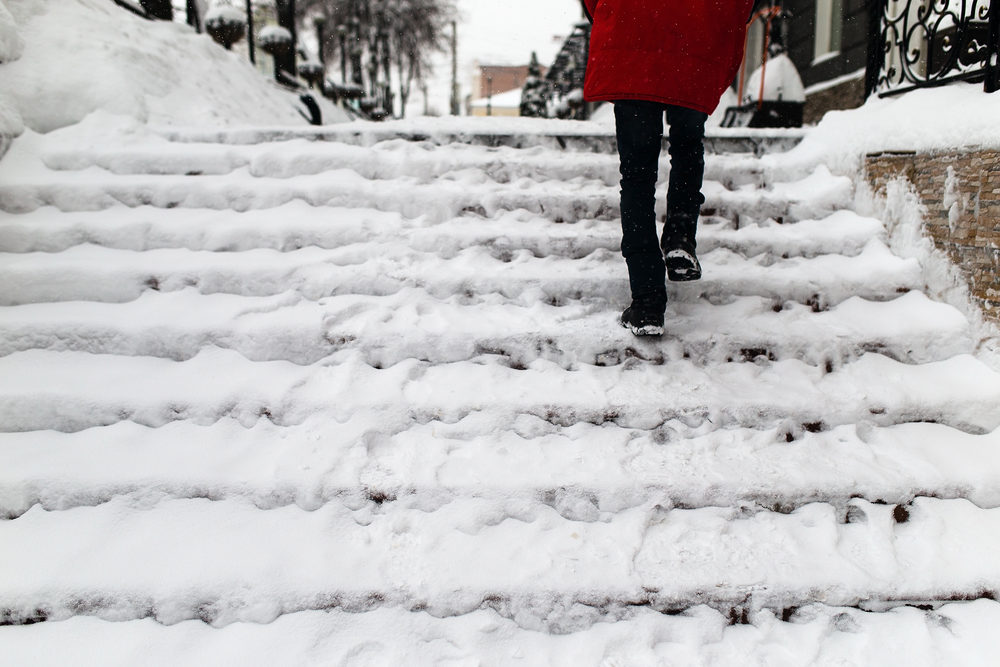 A woman ascends a snow-covered staircase