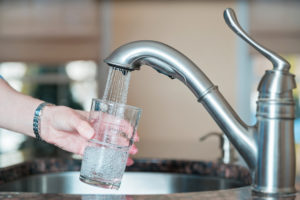 Glass of water being filled at kitchen sink