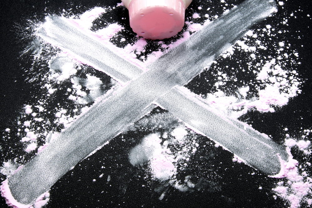Talcum powder on a black surface with a large "X" drawn through it