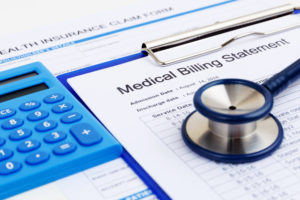 A calculator and stethoscope rest on a Medical Billing Statement
