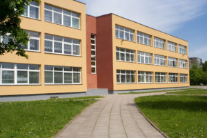 A brown school building lined with windows