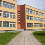 A brown school building lined with windows