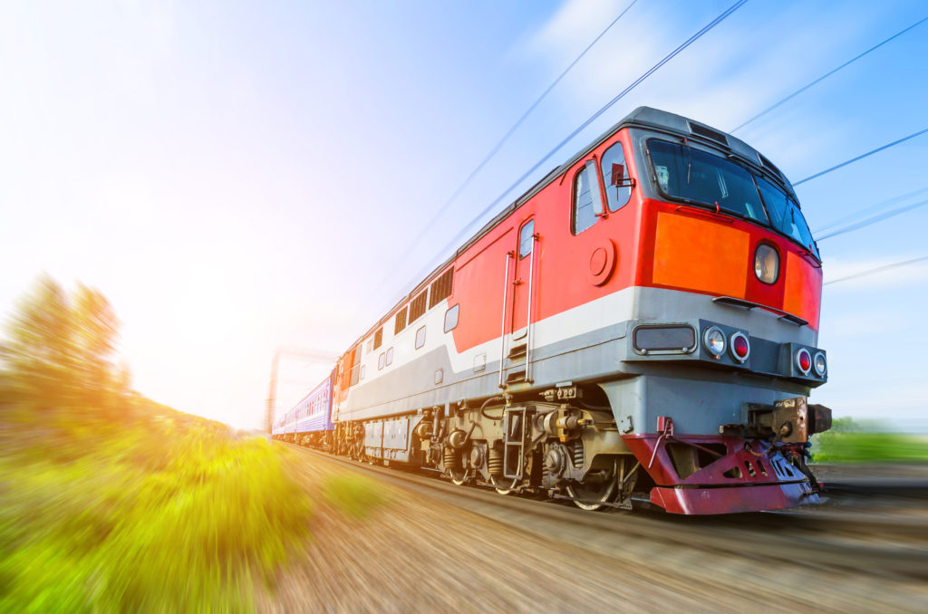 A passenger train speeds through the countryside