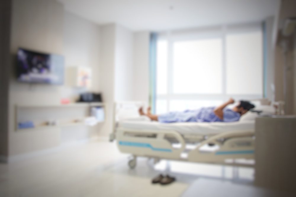 Blurry image of a hospital room with a patient lying in the bed