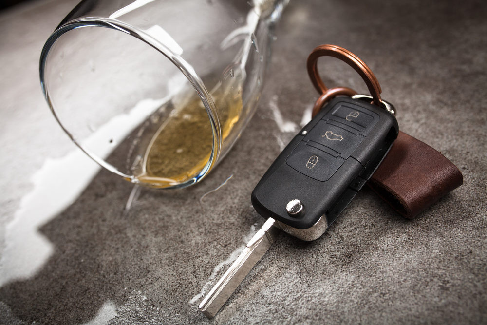 A key fob sits beside a glass of spilled beer