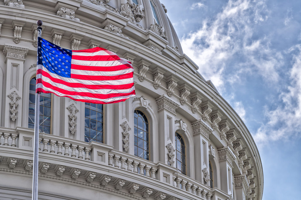 A US flag flaps in front of the Capitol Building in Washington, DC